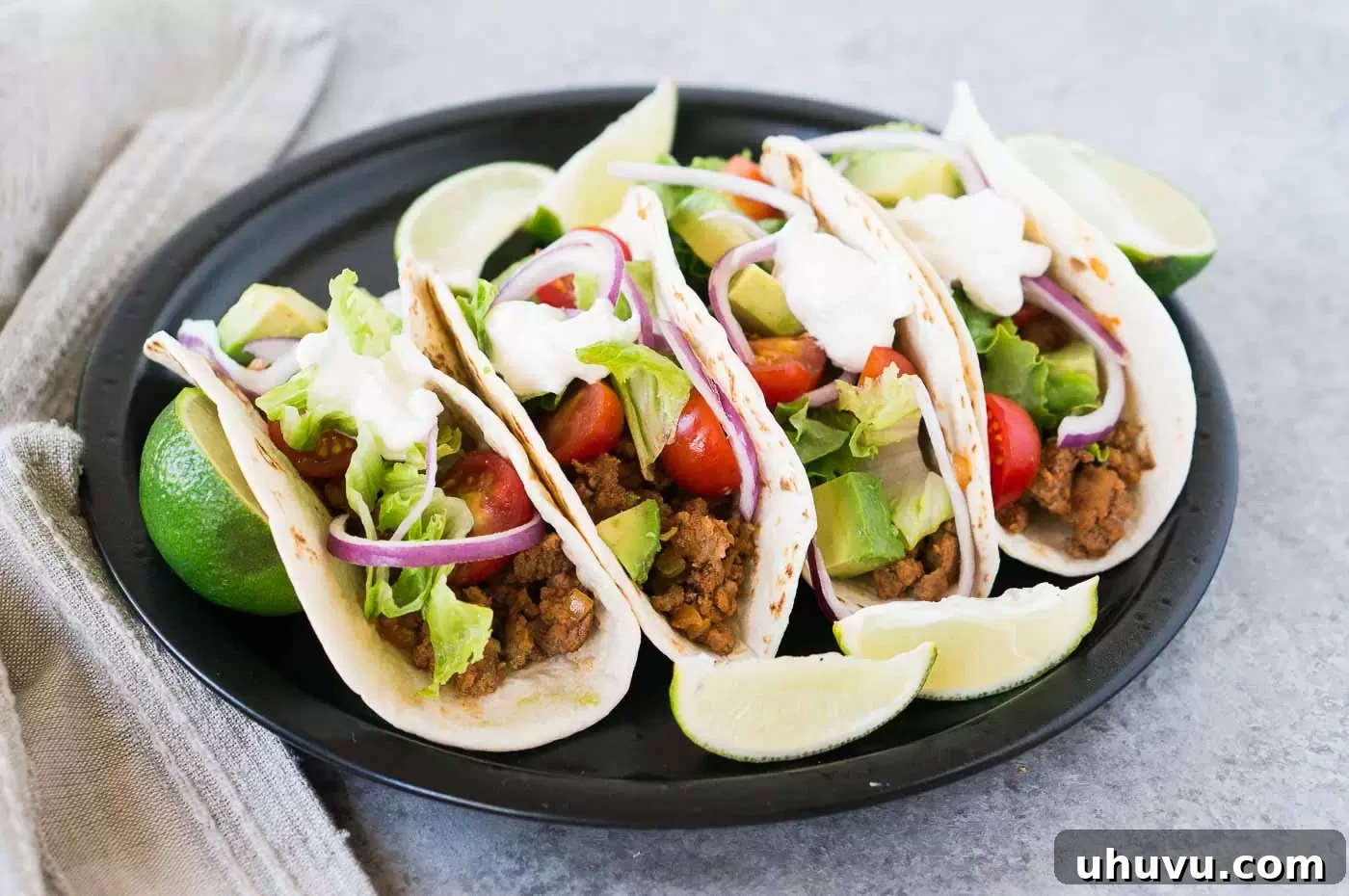 Delicious and vibrant ground beef tacos artfully arranged on a rustic plate, ready for serving.