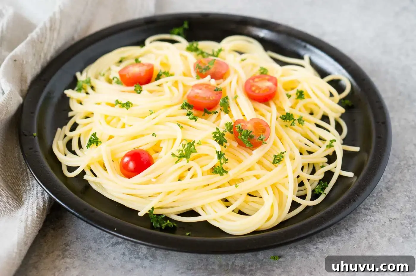 Unlock the Secrets to Perfect Pasta 3 A close-up of freshly cooked pasta mixed with vibrant cherry tomatoes, basil, and a light sauce, presented attractively on a plate.