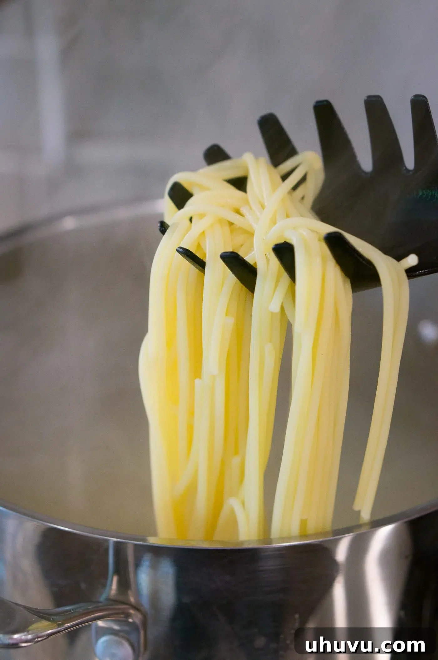 A close-up view of perfectly cooked al dente pasta strands, demonstrating the ideal texture before draining.