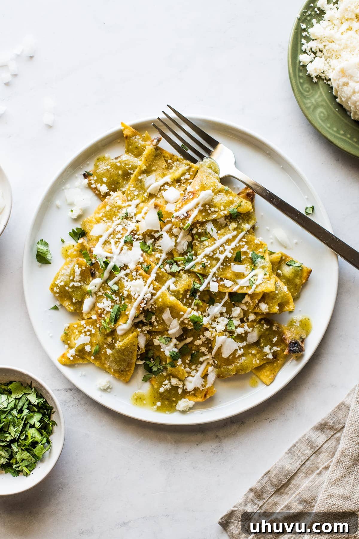 Emerald Chilaquiles 2 A plate of vibrant Chilaquiles Verdes topped with fresh crema and cilantro, ready to be enjoyed.