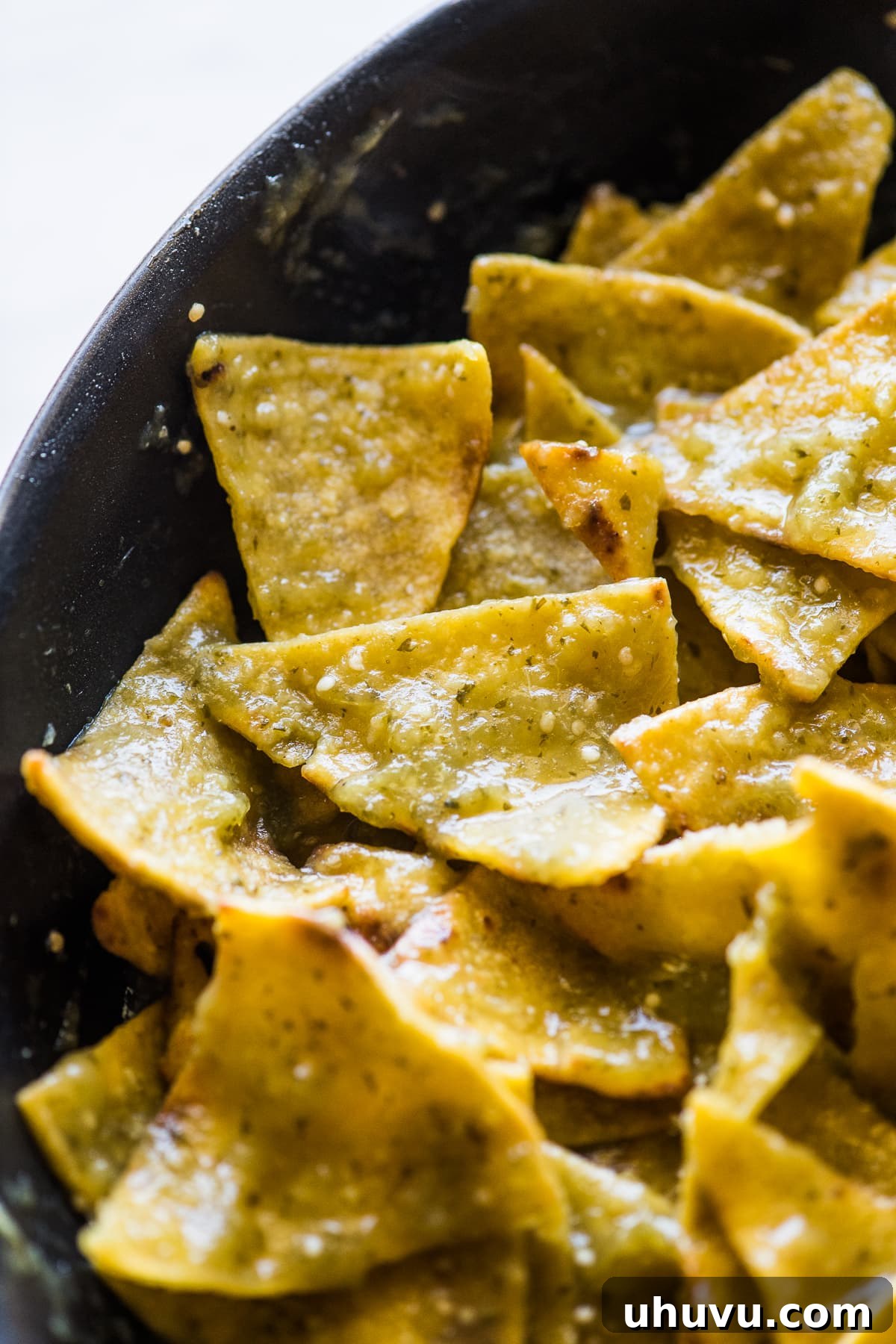 Emerald Chilaquiles 5 Chilaquiles verdes simmering in a skillet, coated in green salsa.