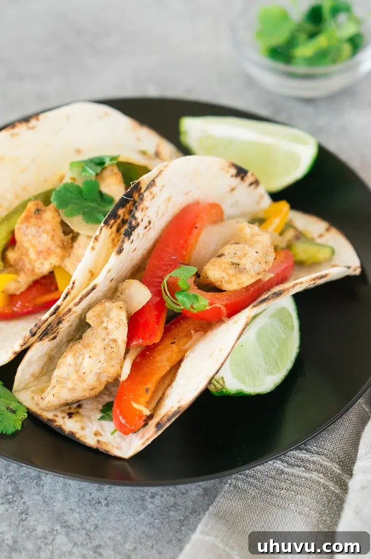 baked chicken fajitas in tortillas on a plate