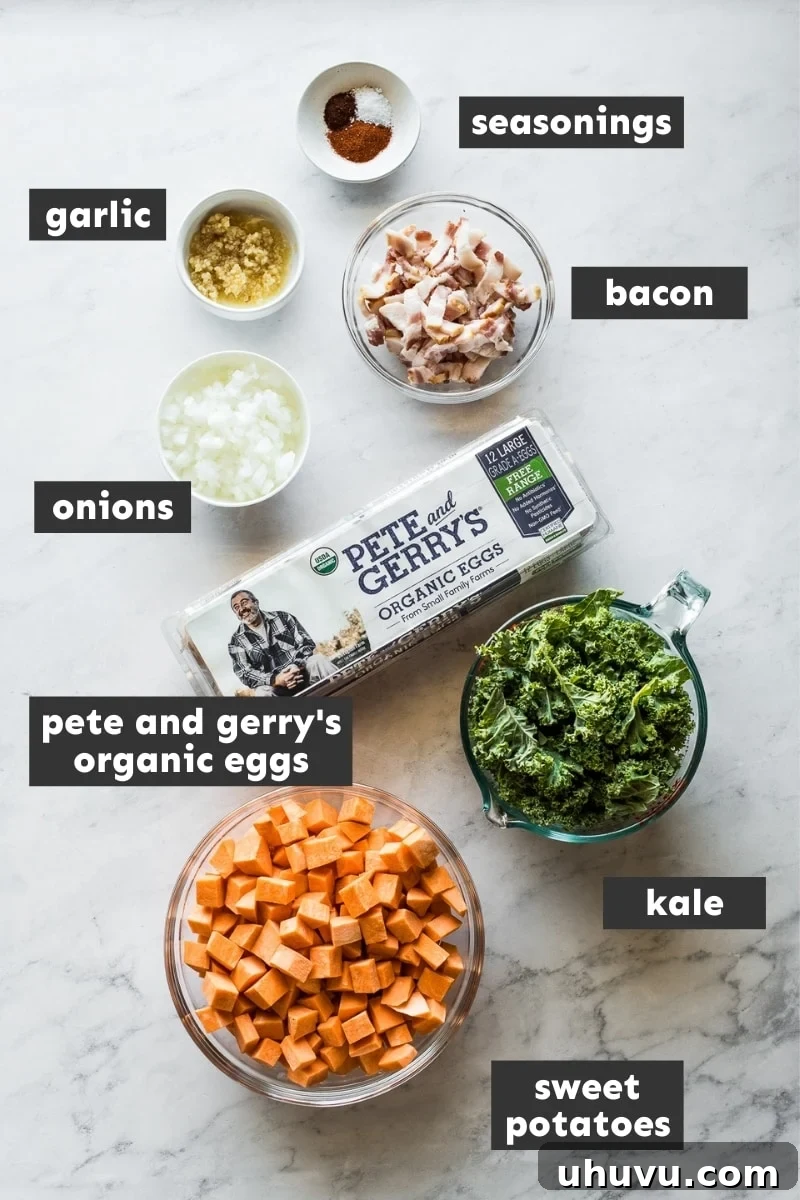 Sheet Pan Breakfast Bake 3 Fresh ingredients for sheet pan eggs and breakfast hash laid out on a wooden table, including sweet potatoes, kale, onions, garlic, and spices.