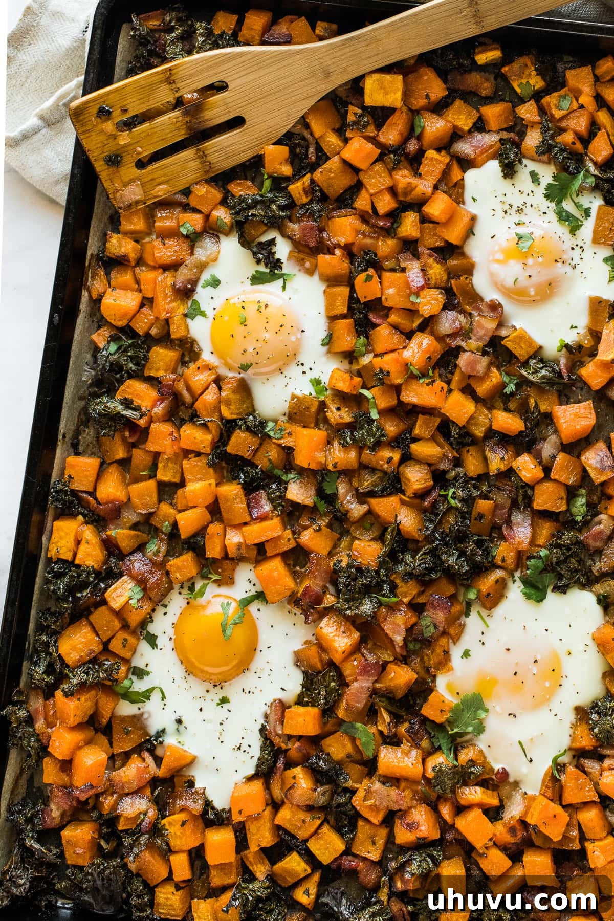 Sheet Pan Breakfast Bake 6 Perfectly cooked sheet pan eggs nestled within the savory sweet potato and kale hash, ready to be enjoyed.