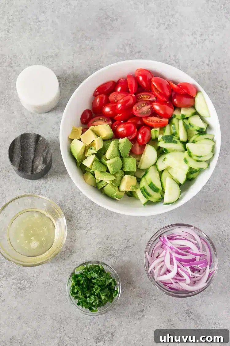 Fresh ingredients for tomato avocado cucumber salad laid out