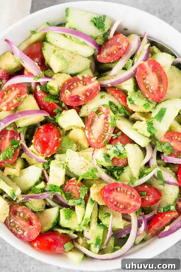 Close-up of fresh Tomato Cucumber Avocado Salad in a white bowl