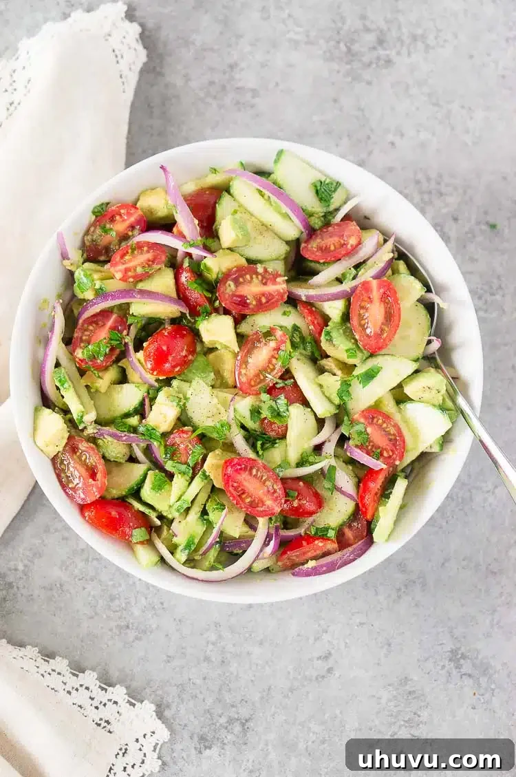 Serving of tomato cucumber and avocado salad in a white bowl