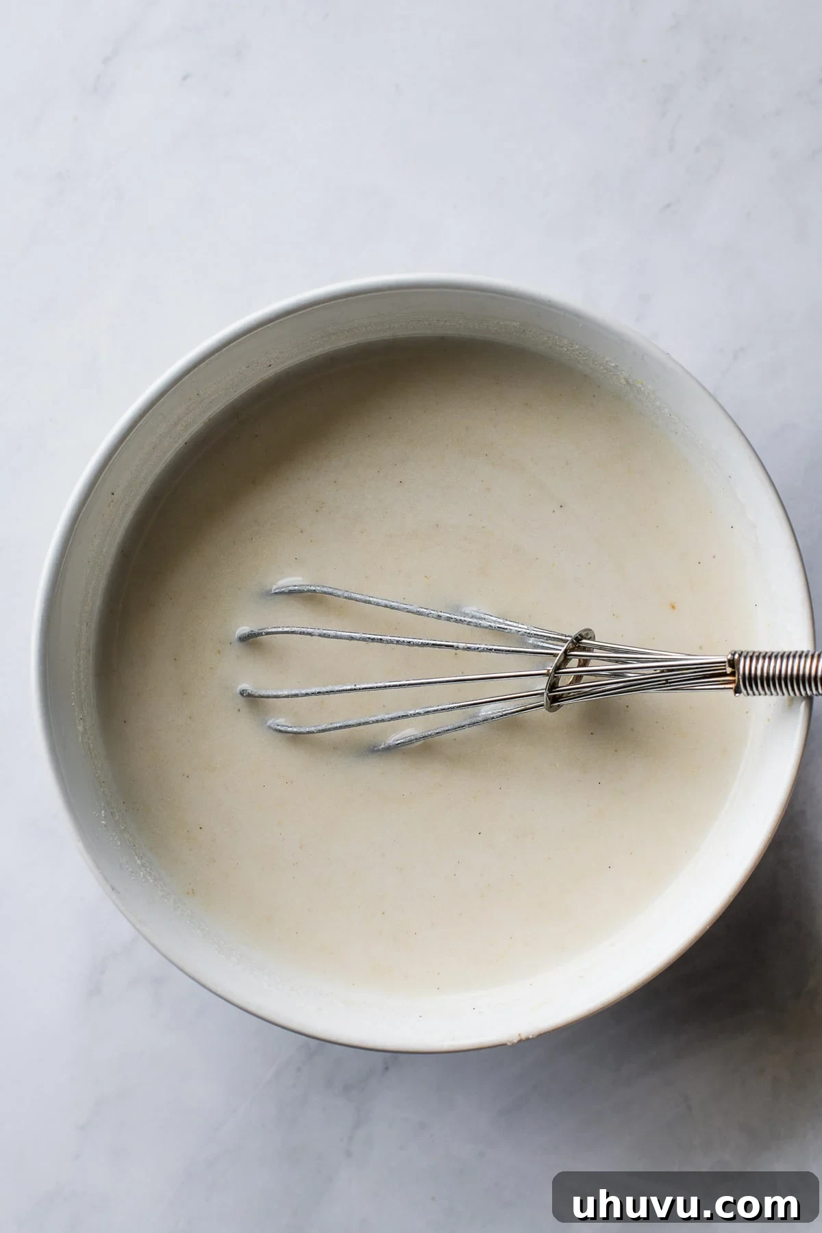 The Comforting Warmth of Mexican Atole 6 A small bowl containing a smooth, whisked mixture of masa harina and warm water, ready to be added to the atole base.