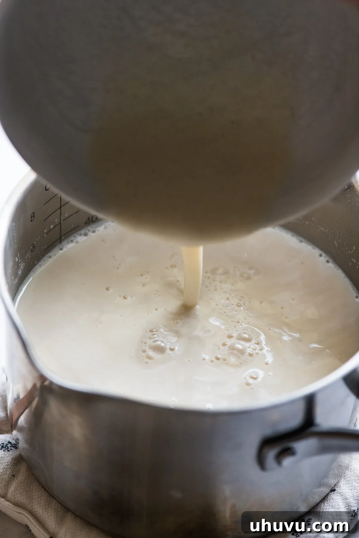 The Comforting Warmth of Mexican Atole 7 The smooth masa harina mixture being poured into the saucepan with the warm milk and piloncillo for atole.