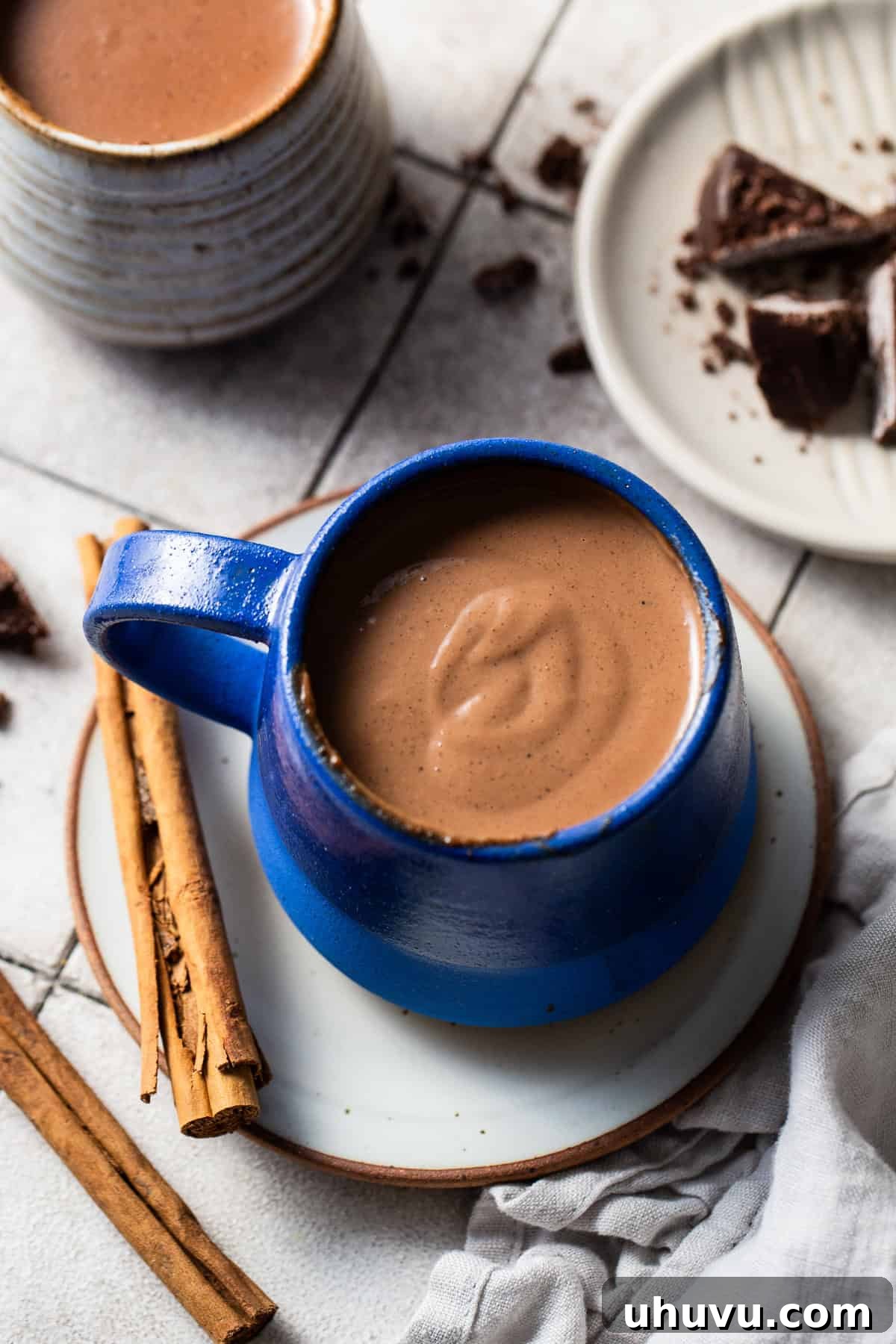 Velvet Corn Chocolate 8 A serving of champurrado in a mug with cinnamon sticks on the side.