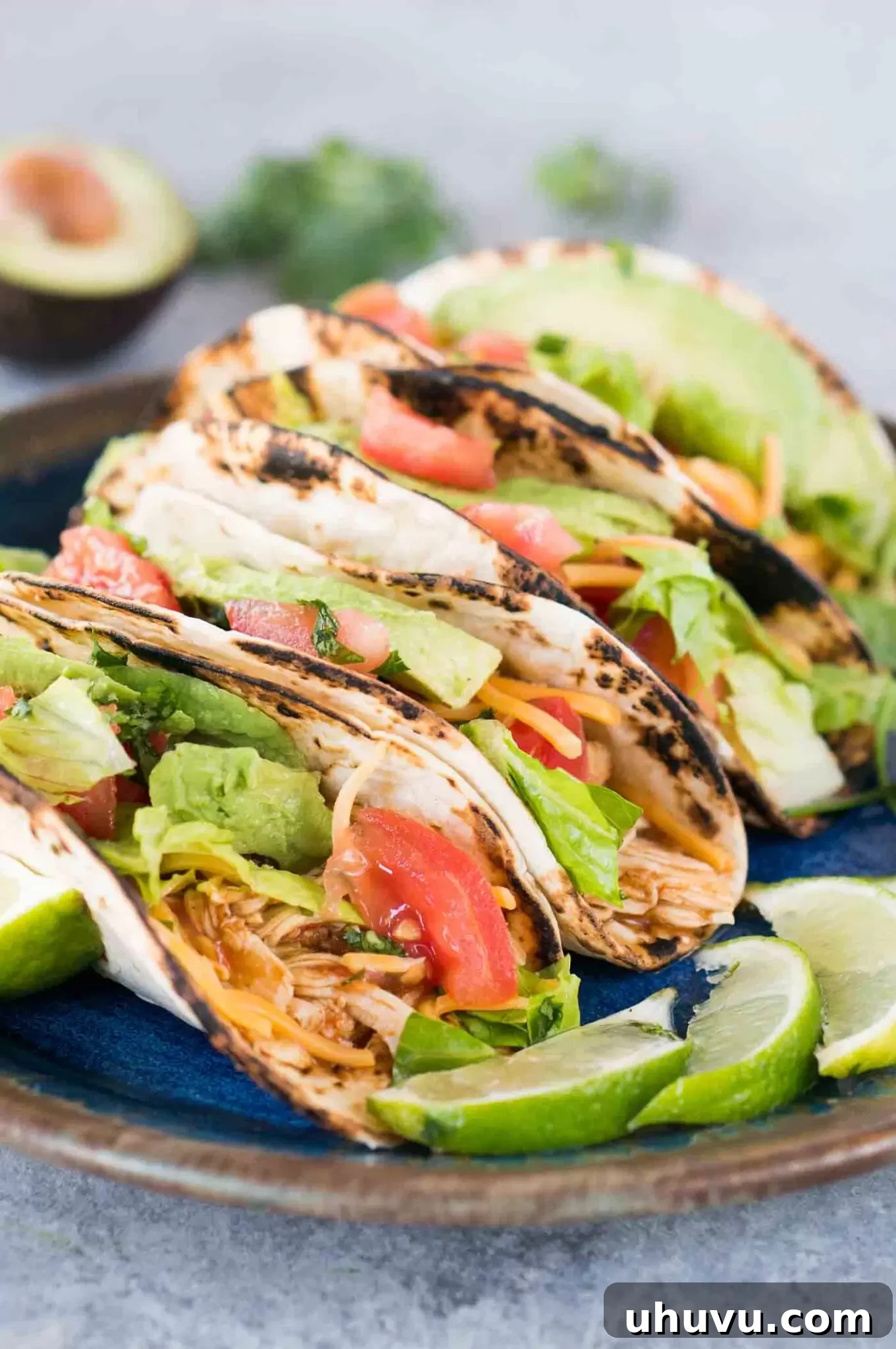 close up image of instant pot chicken tacos with fresh cilantro and lime