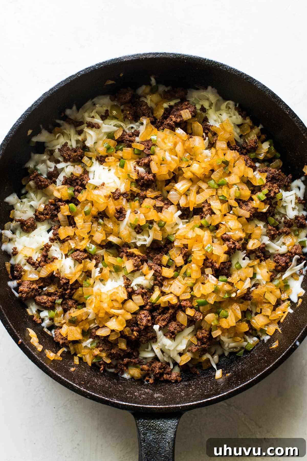 Ultimate Cheese Dip 4 Sauteed onions, peppers, and chorizo in a skillet for queso fundido.