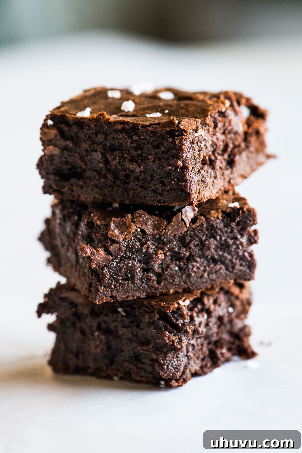 Aztec Chocolate Brownies 4 Three decadent fudgy Mexican brownies stacked, showing their rich chocolate color and inviting texture.