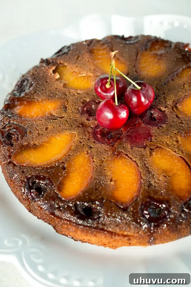 Close-up of a slice of Peach Cherry Upside Down Cake showing the juicy fruit and moist crumb.
