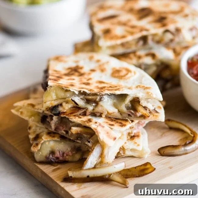 Steak quesadillas with melted cheese and sauteed onions.