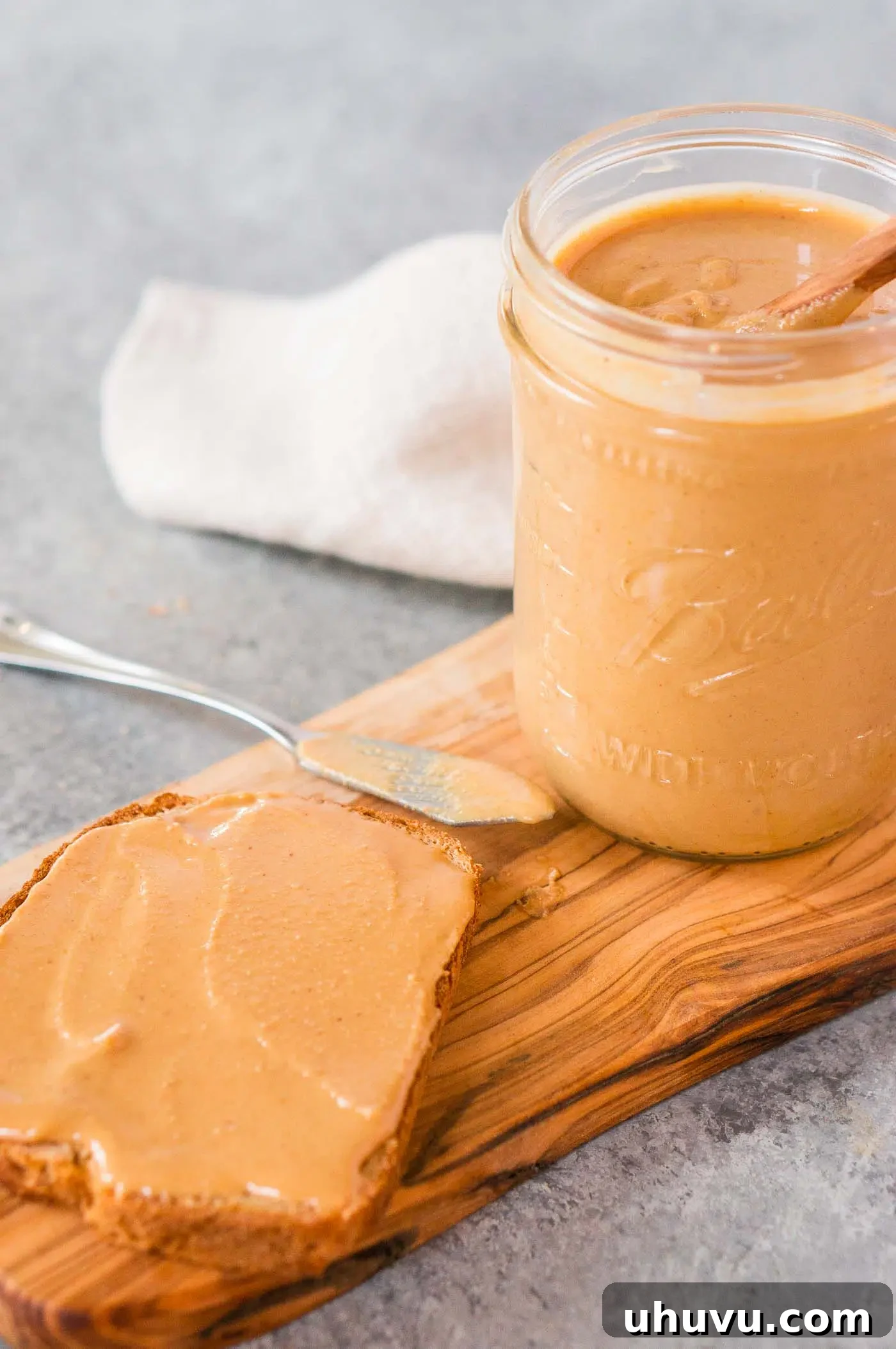 homemade peanut butter generously spread on a slice of bread