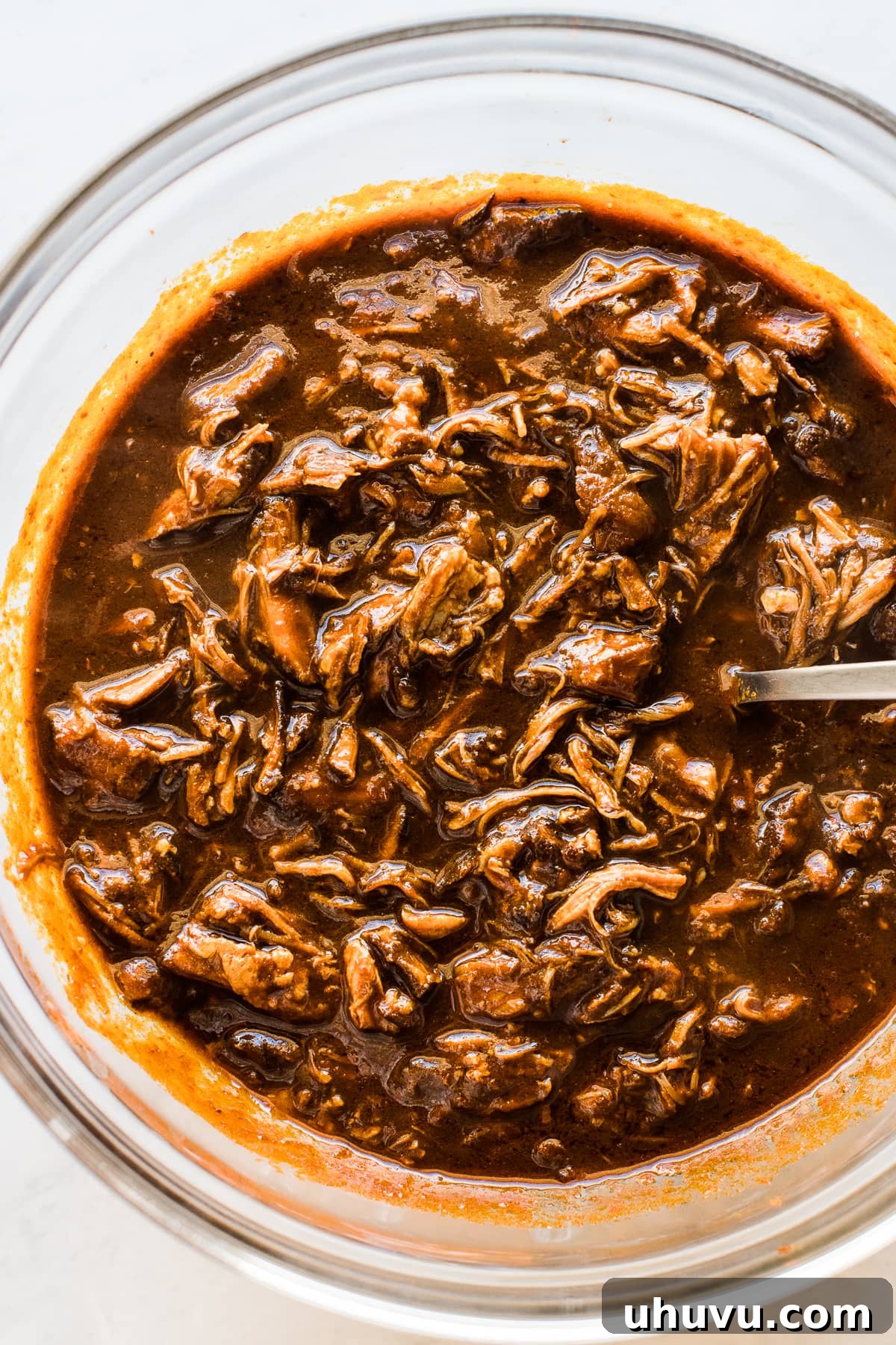 Pork in red chile sauce for Instant Pot Pork Tamales, ready to be shredded.
