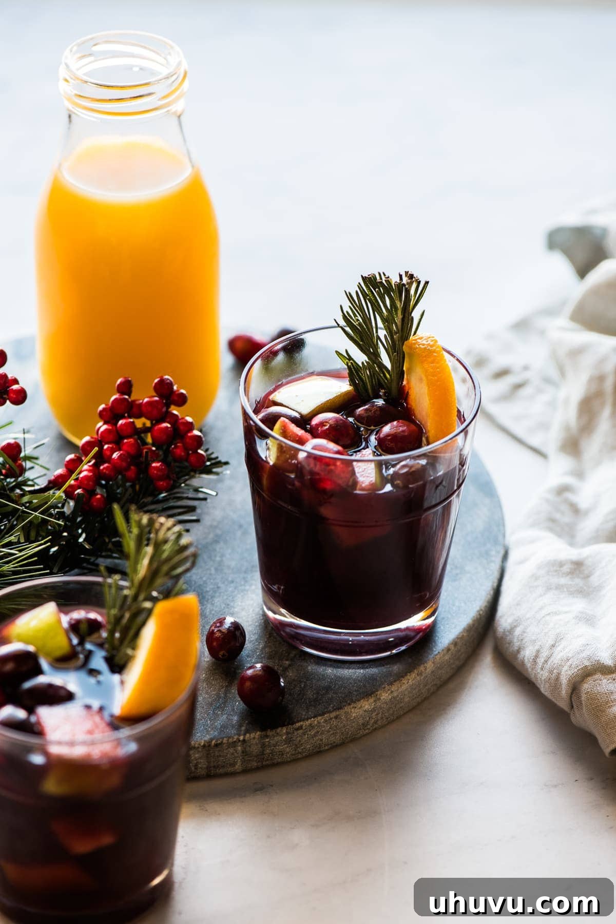 Fireside Sangria 2 Winter sangria topped with cranberries, rosemary, and orange slices.