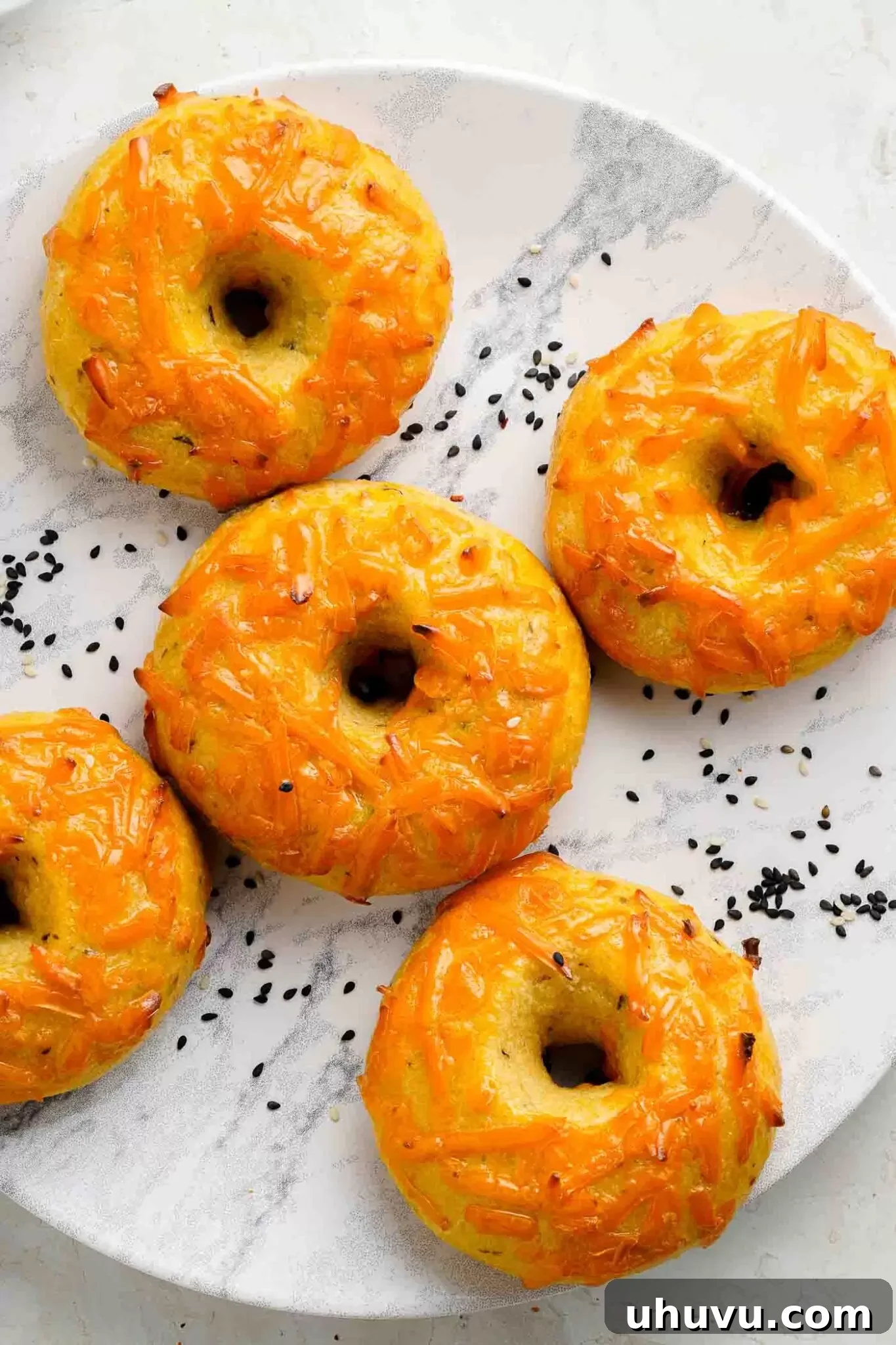 A plate of freshly baked, golden brown keto cheese bagels, perfect for a healthy breakfast.