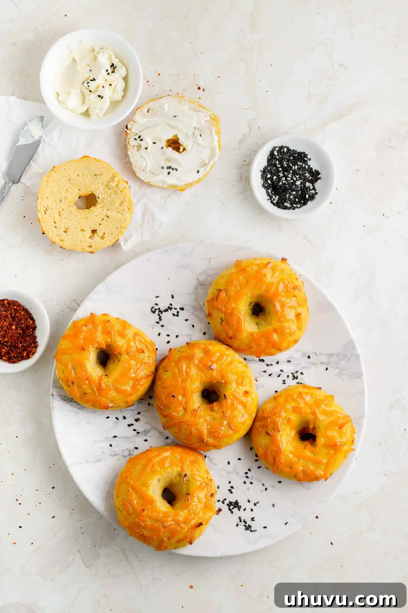 Golden Cheese Bagels 9 A stack of perfectly baked cheese bagels on a white plate, ready for serving.