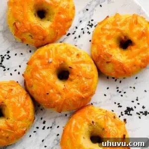 A single keto cheese bagel on a white plate, highlighting its texture and golden crust.