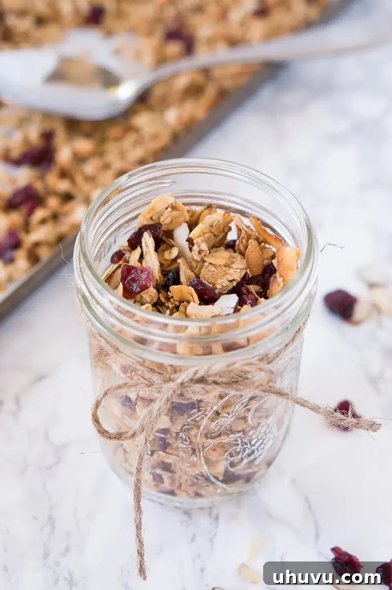 Freshly made homemade granola stored in a clear mason jar with a label, ready for storage.
