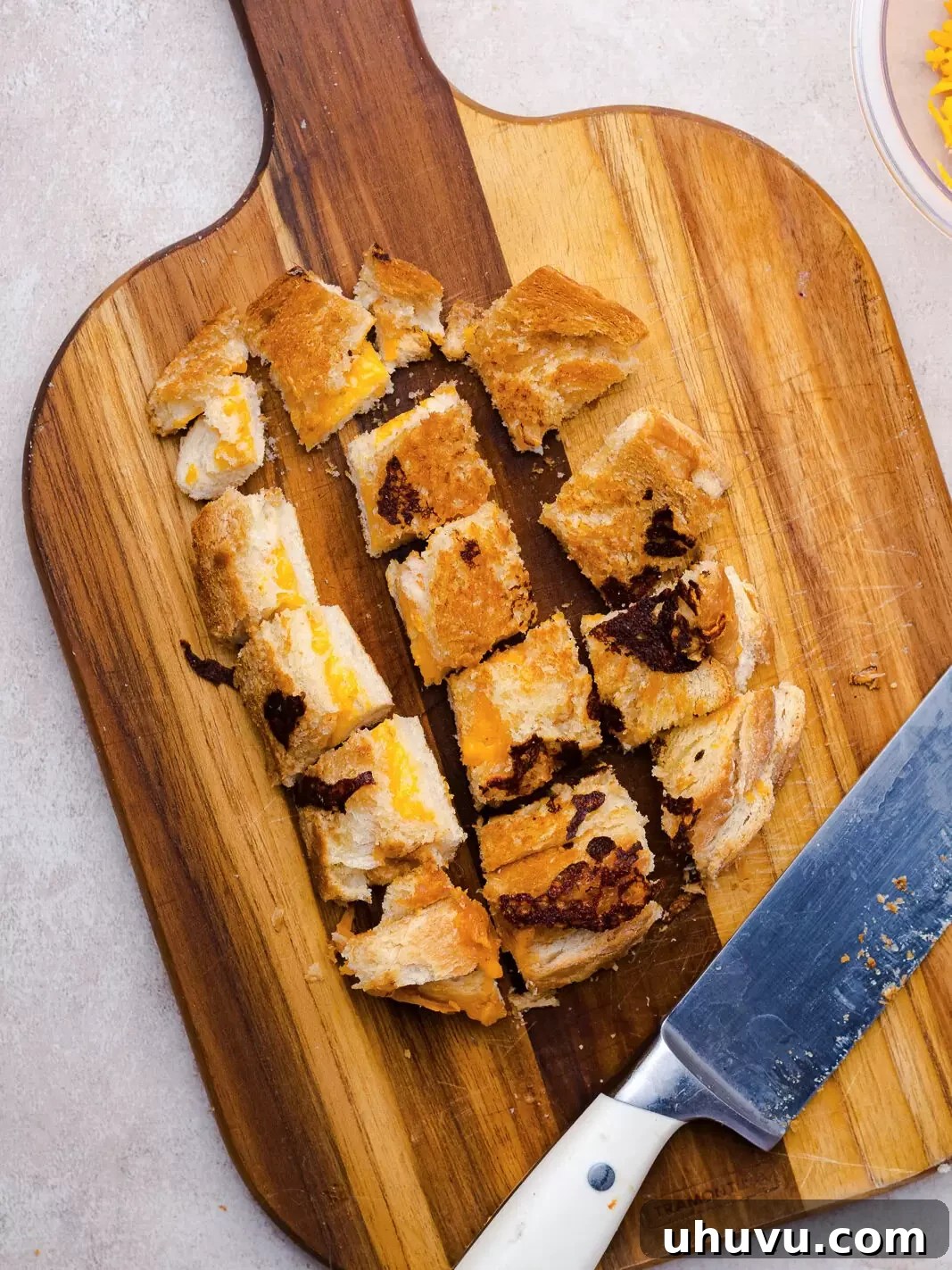 cut grilled cheese croutons on a cutting board