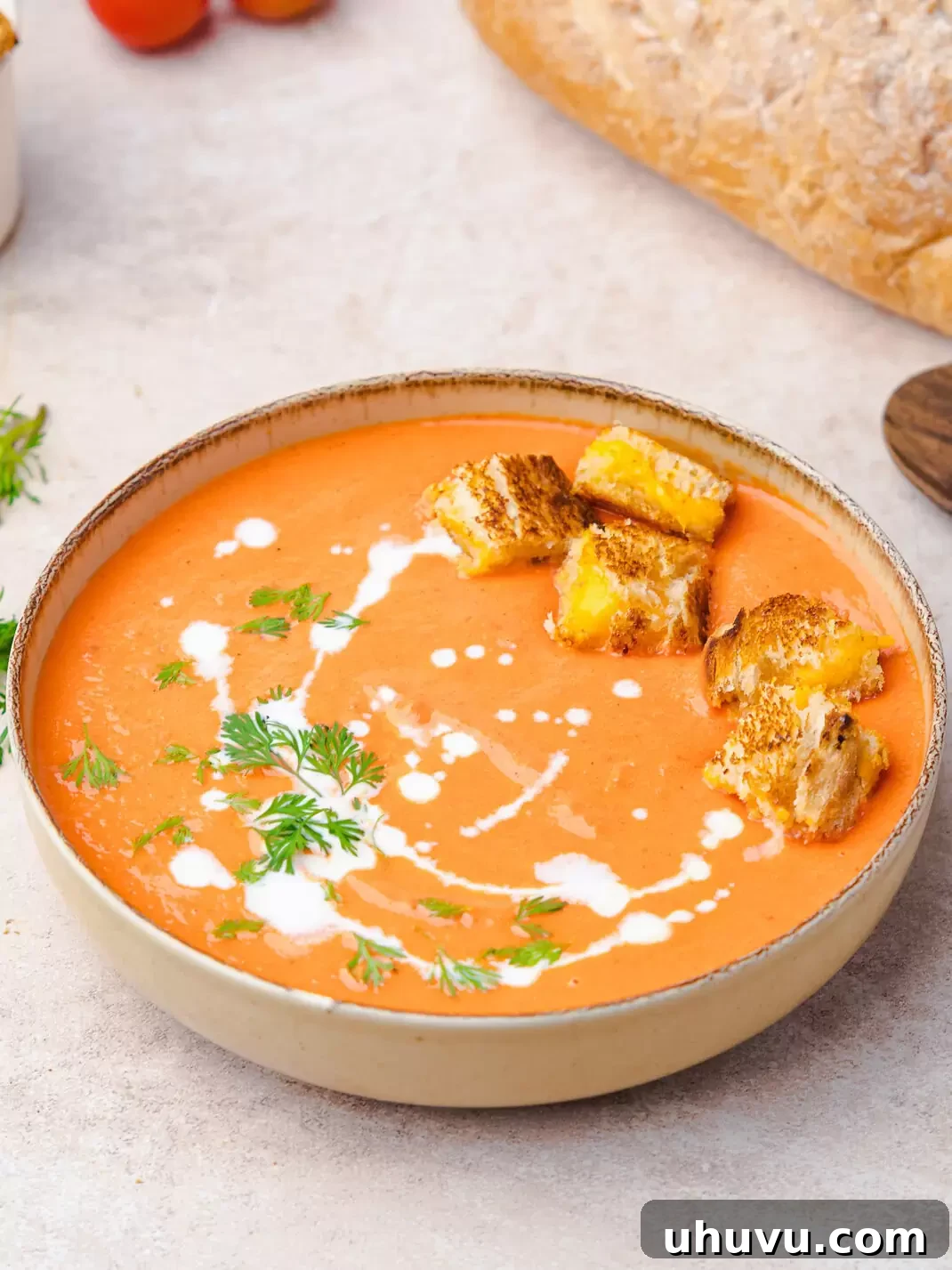 roasted tomato soup in a bowl with grilled cheese croutons
