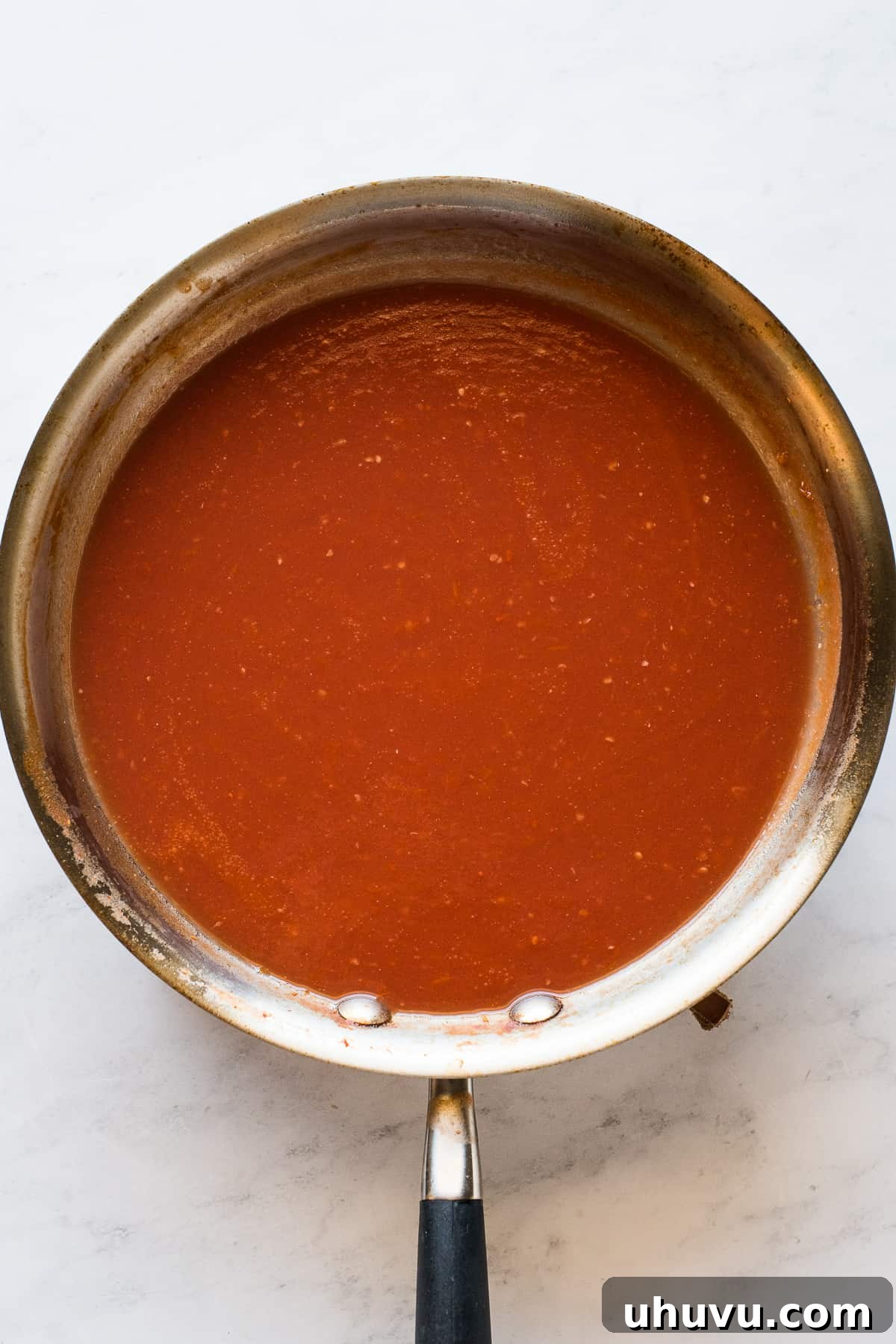 Tomato-Smothered Tortillas 6 The blended tomato-based sauce for entomatadas simmering in a skillet on the stove.