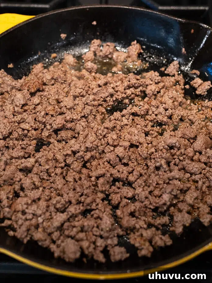 cooking ground beef in a skillet for moussaka