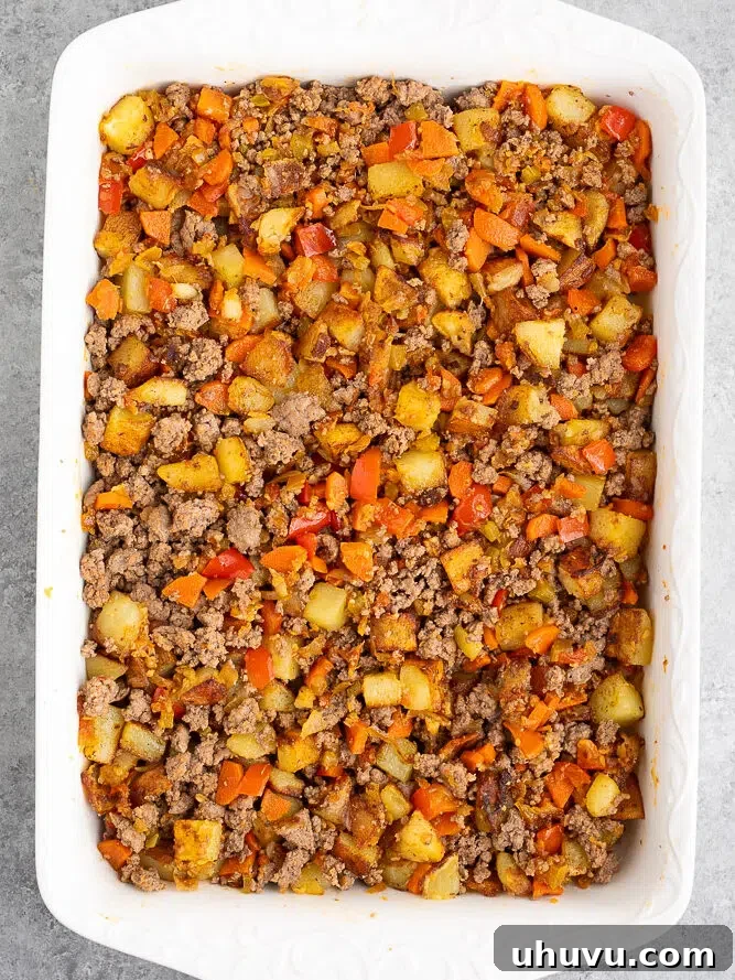 vegetables and ground beef in a casserole dish for moussaka