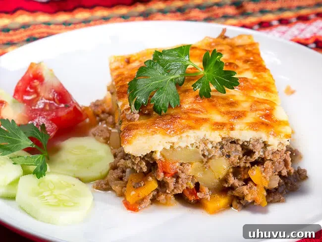 Bulgarian Moussaka on a plate with tomato cucumber salad