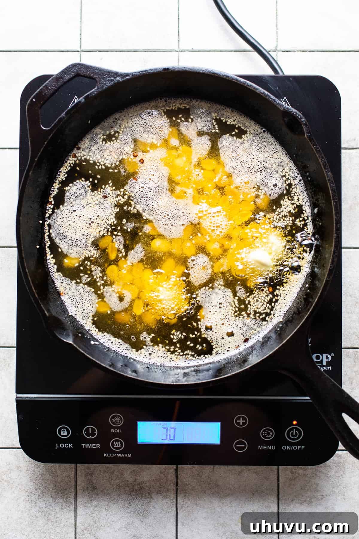 Garlic cloves, peanuts, and sesame seeds frying in oil