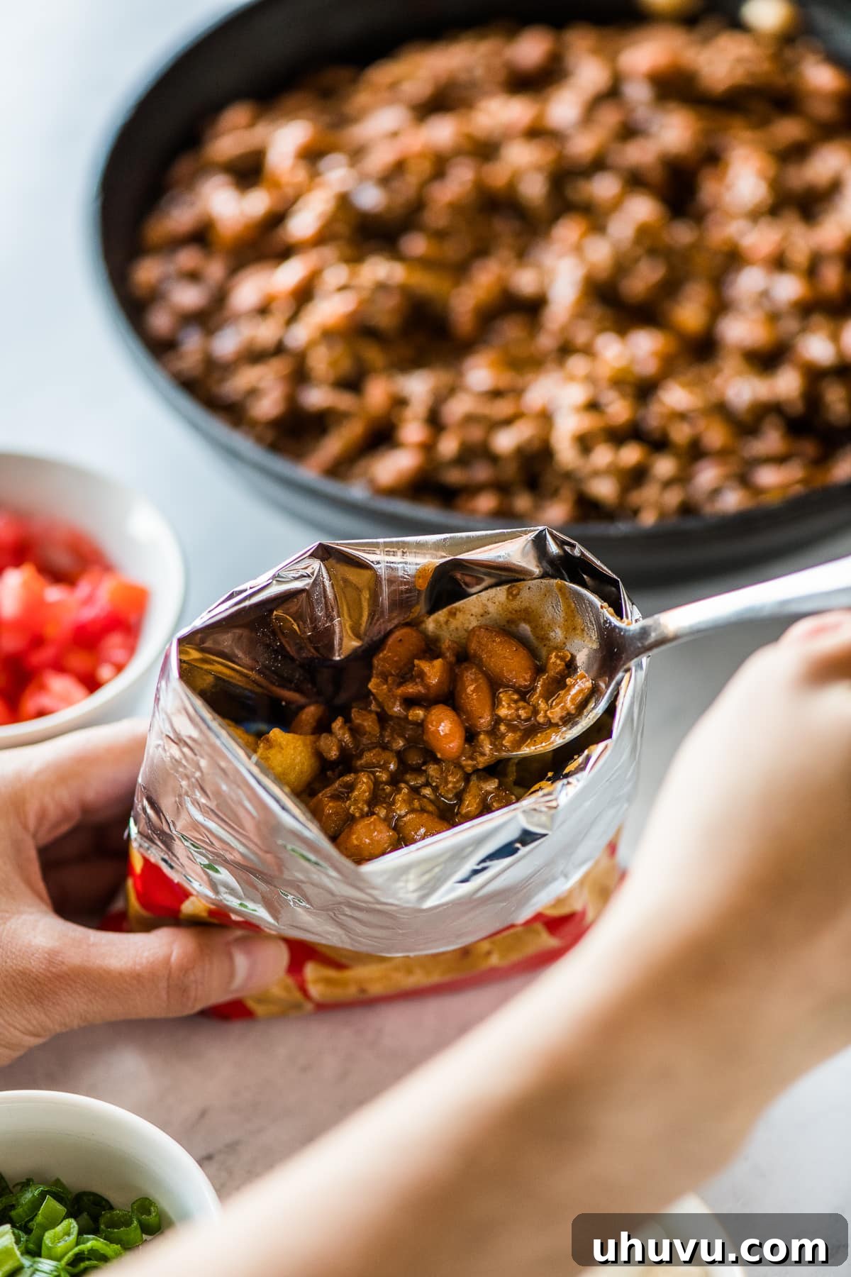 Chip Bag Tacos 5 A hand adding filling to a bag of corn chips for making walking tacos.