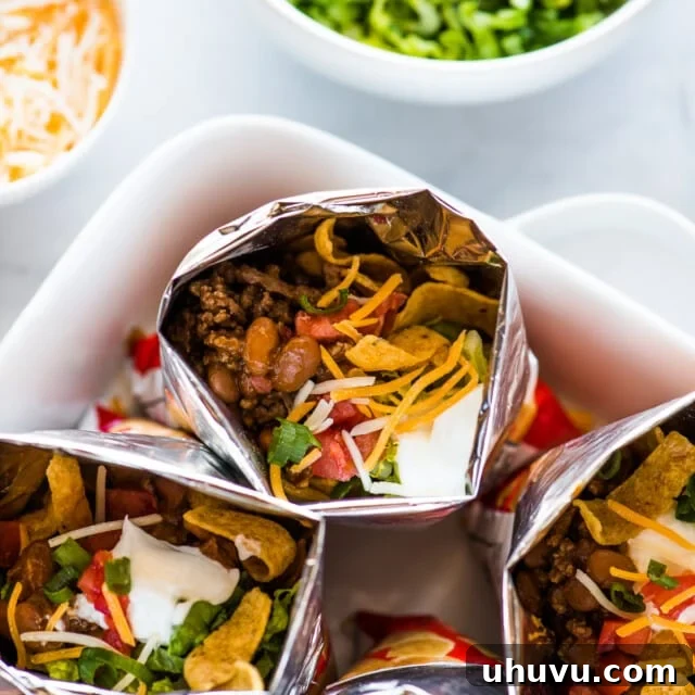 Bags of walking tacos filled with beef, beans, cheese, sour cream, tomatoes, and more.