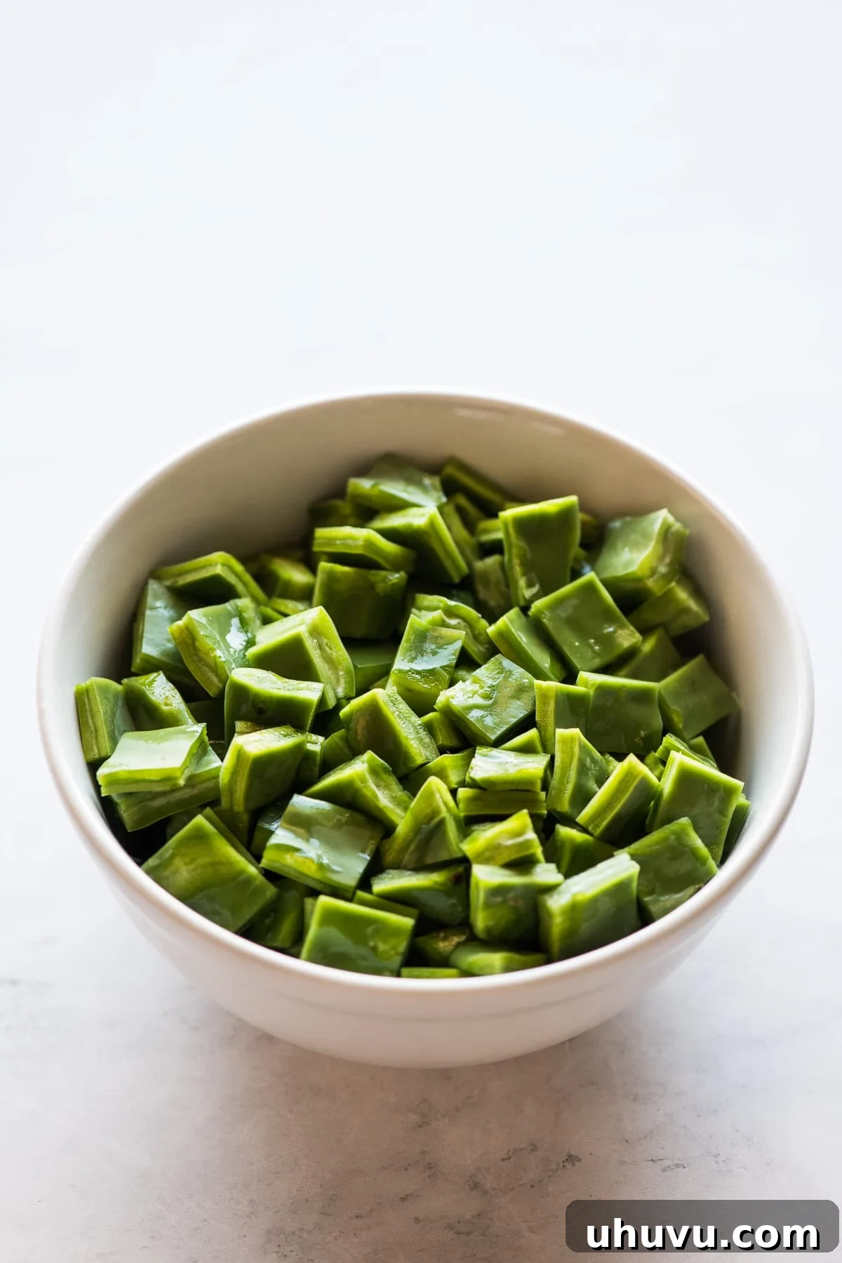 Nopales Made Easy 5 A bowl of diced nopales (cactus paddles) ready to be cooked, showcasing their vibrant green color and uniform cuts.