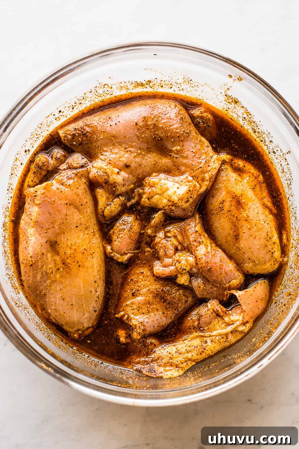 Speedy Instant Pot Chicken Tacos 3 Chicken marinating in a large mixing bowl.