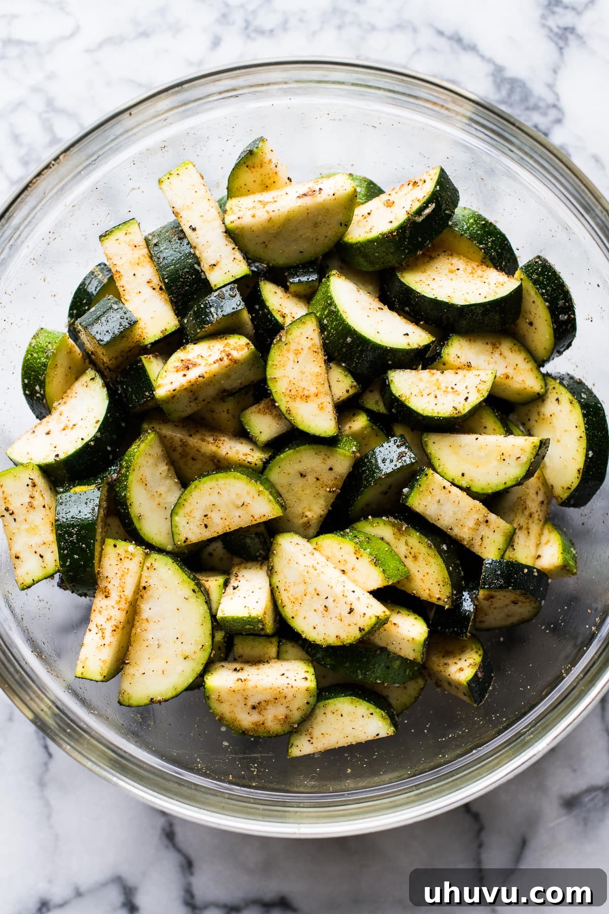 Zesty Roasted Mexican Zucchini 3 Sliced zucchini in a bowl tossed with spices.