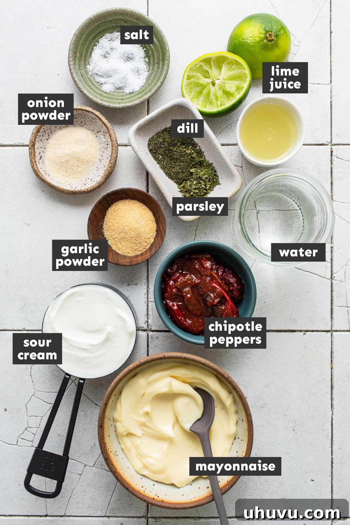 Velvet Heat Ranch 4 A selection of fresh ingredients neatly arranged on a table, including mayonnaise, sour cream, a can of chipotle peppers in adobo sauce, a lime, and various dried herbs and spices, ready to be transformed into chipotle ranch.