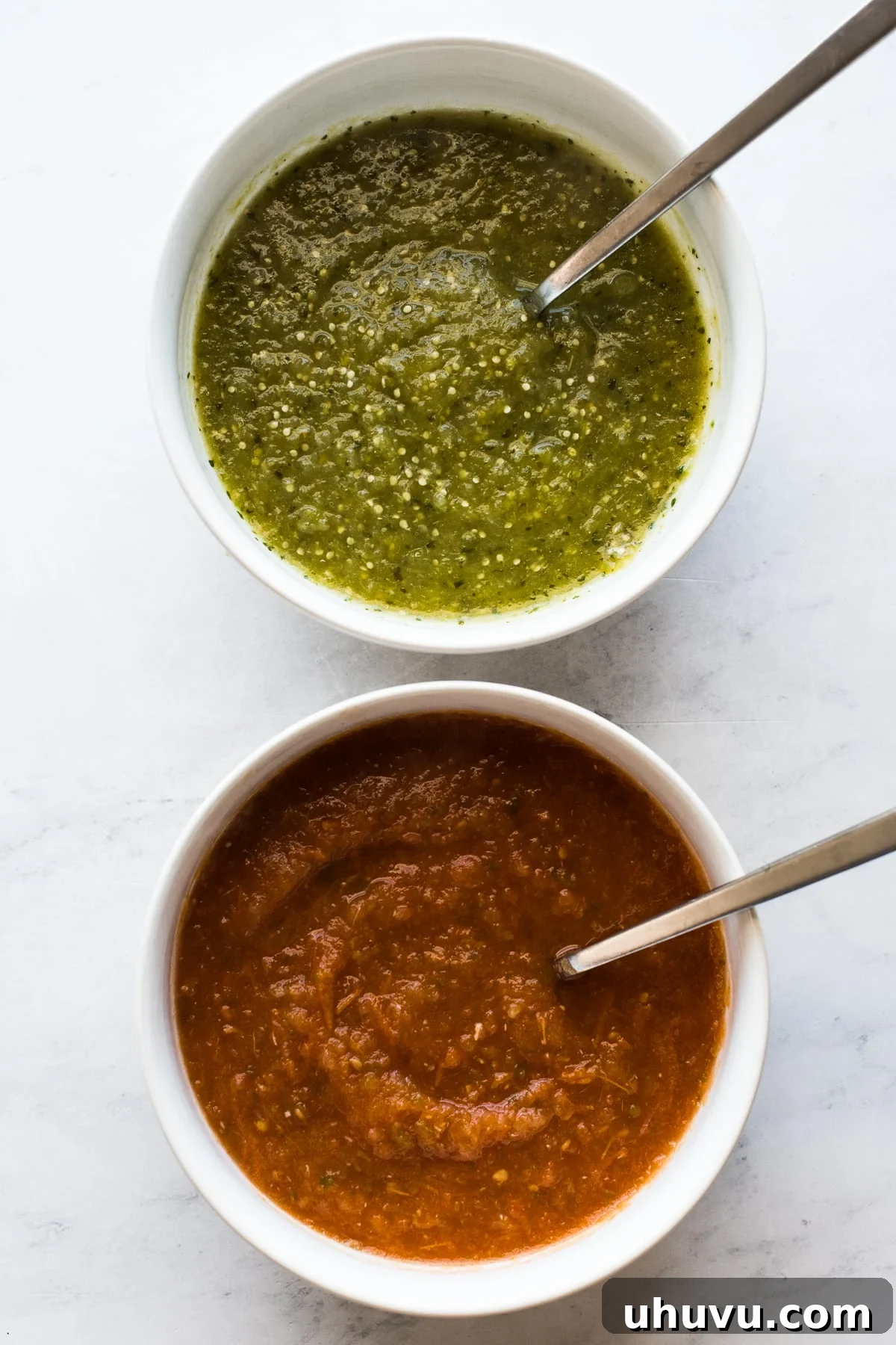 Divorced Eggs 4 Two bowls, one containing vibrant red salsa roja and the other fresh green salsa verde, prepared for Huevos Divorciados.