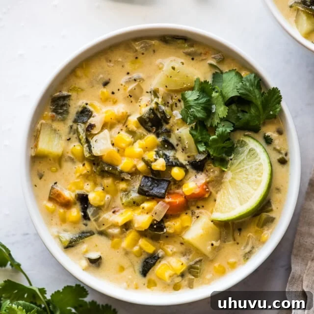 Smoky Roasted Poblano Corn Chowder 7 Roasted poblano corn chowder in a bowl topped with cilantro and a lime wedge.