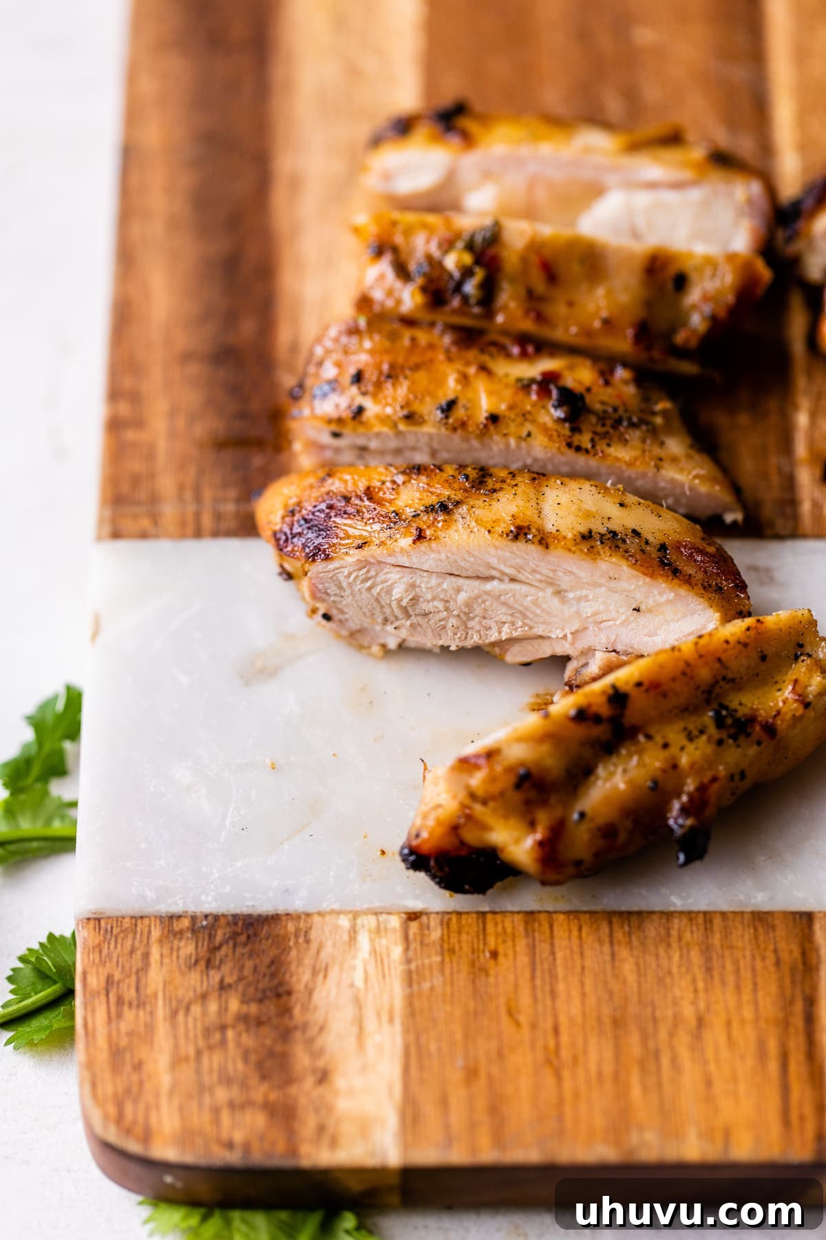 Vibrant Lime Chicken Marinade 5 Perfectly sliced juicy lime marinated chicken on a wooden cutting board, revealing its tender texture.