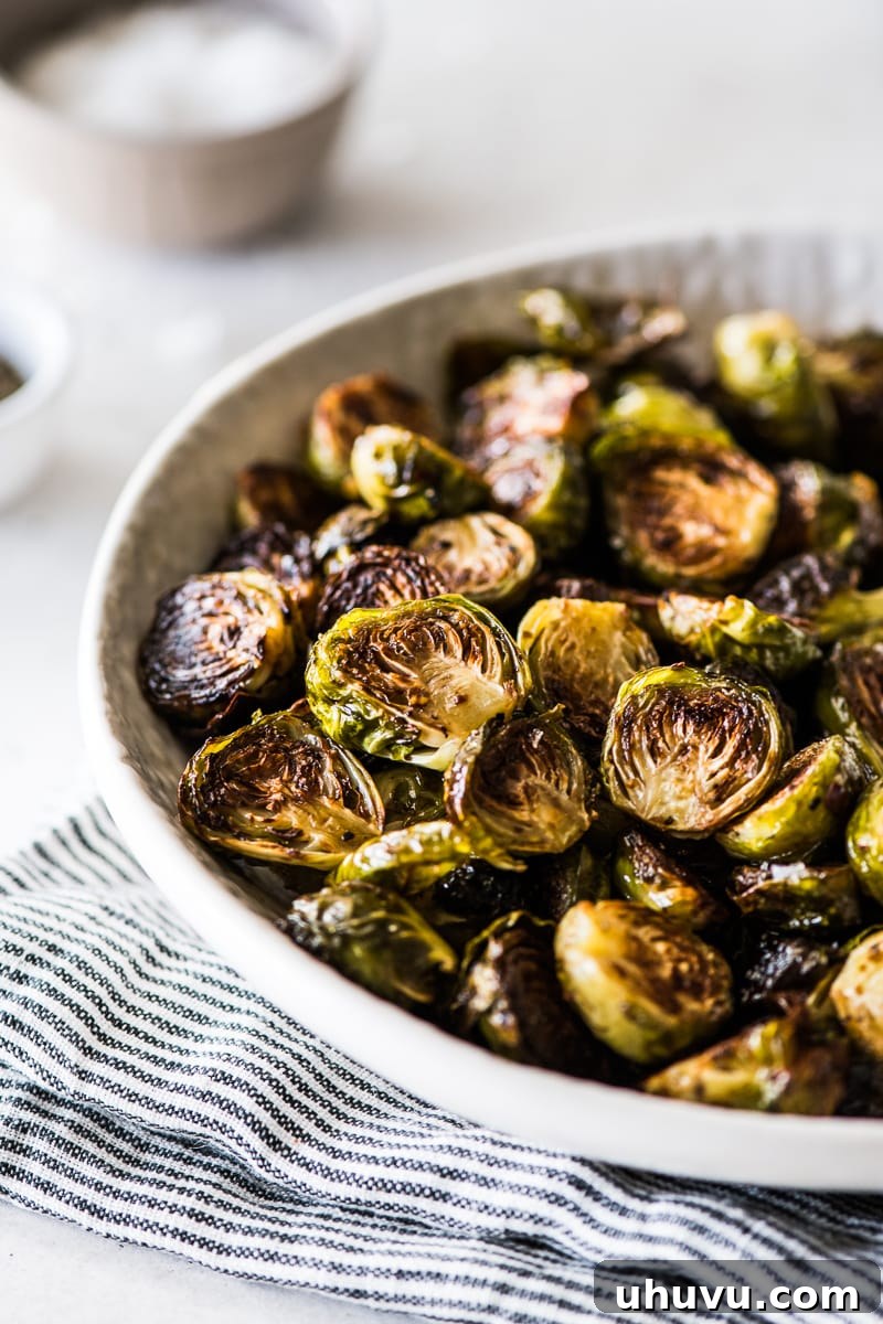 Caramelized Honey Balsamic Sprouts 2 A serving of glossy Honey Balsamic Brussels Sprouts in a pristine white bowl, garnished and ready to be enjoyed. The sprouts show a perfect balance of tenderness and crispiness, with a rich, caramelized sheen from the honey and balsamic glaze.