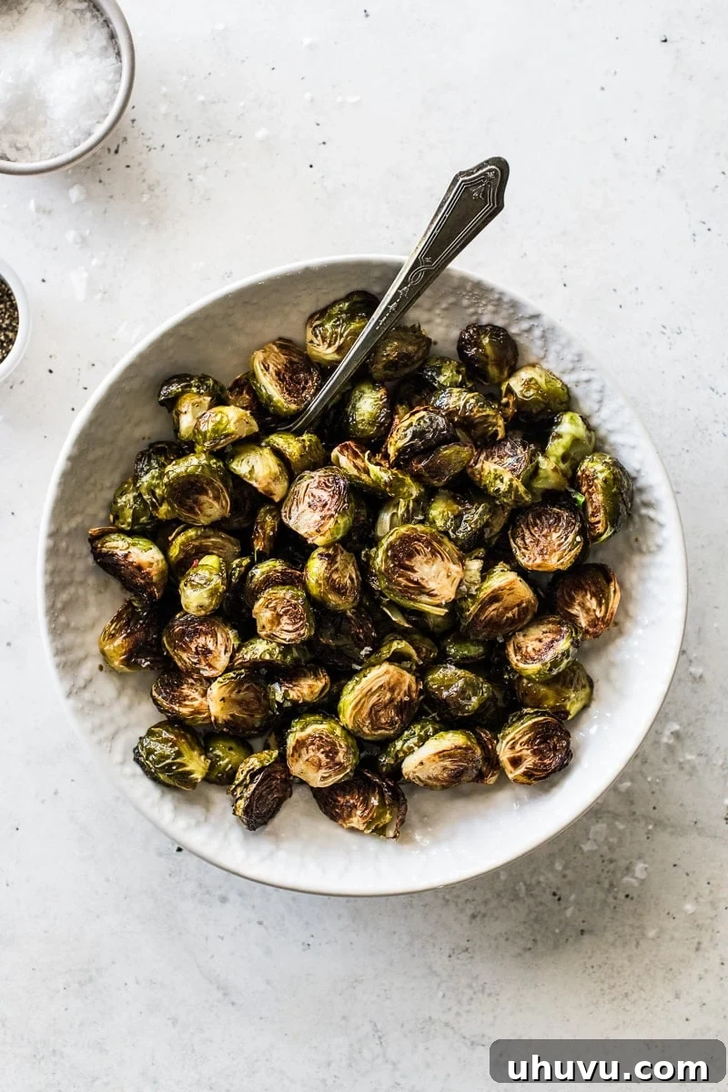 Caramelized Honey Balsamic Sprouts 7 A close-up of roasted honey balsamic Brussels sprouts in a rustic serving bowl, lightly garnished with sea salt flakes, highlighting their appealing texture and glaze.