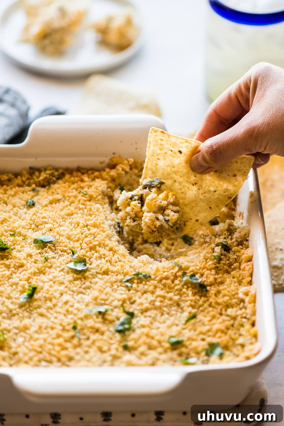 A tortilla chip scooping up creamy chile relleno dip.