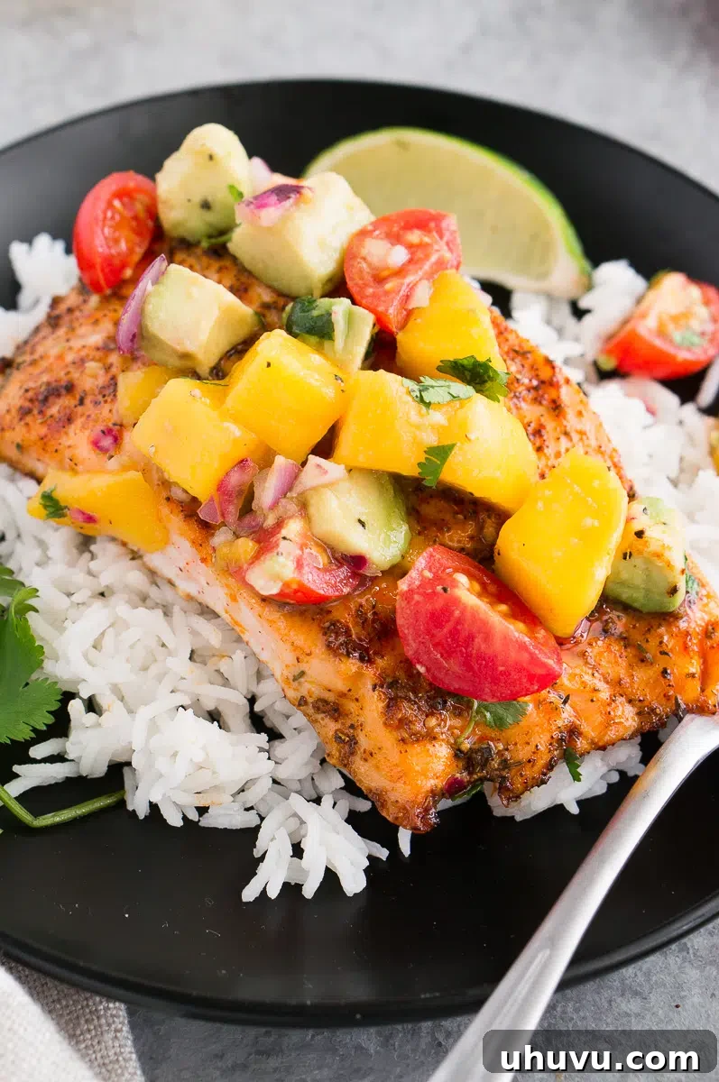 close up image of salmon with avocado mango salsa