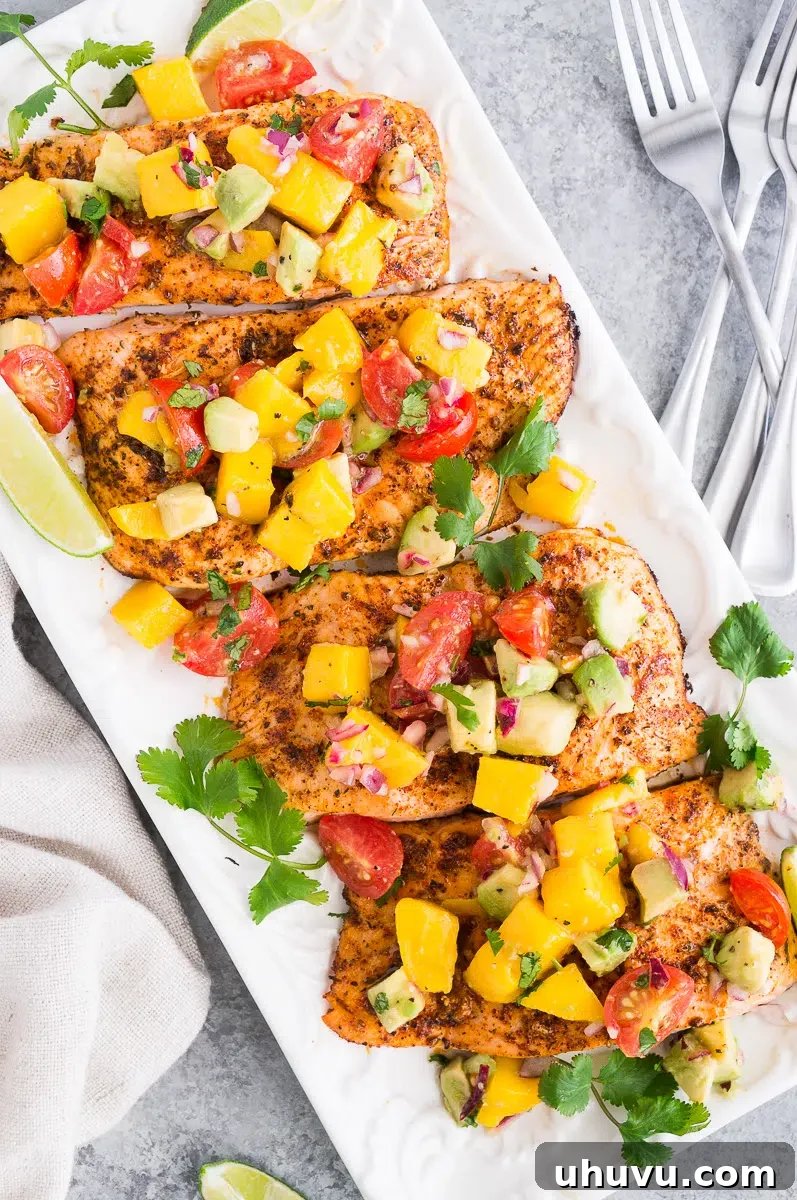 salmon fillets topped with mango avocado salsa on a platter
