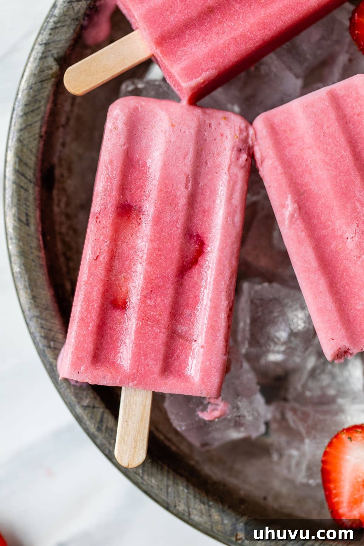 Strawberry Cloud Pops 6 Frozen strawberry paletas on ice.