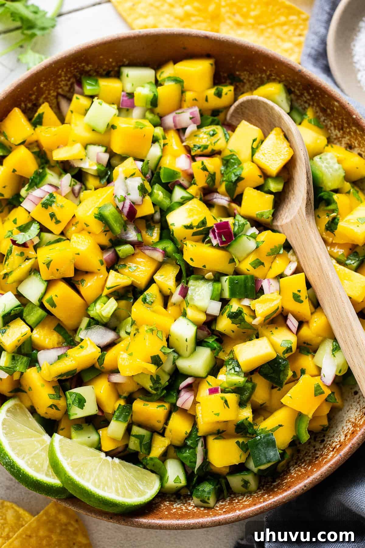 Tropical Mango Medley 2 Vibrant mango salsa ready to be served in a large wooden bowl, garnished with fresh cilantro.