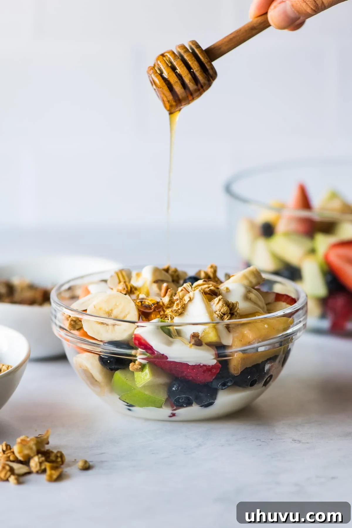 Bionicos Fiesta Fruit Bowls 5 Honey being drizzled over a freshly prepared Bionico bowl, enhancing its sweetness and appeal.